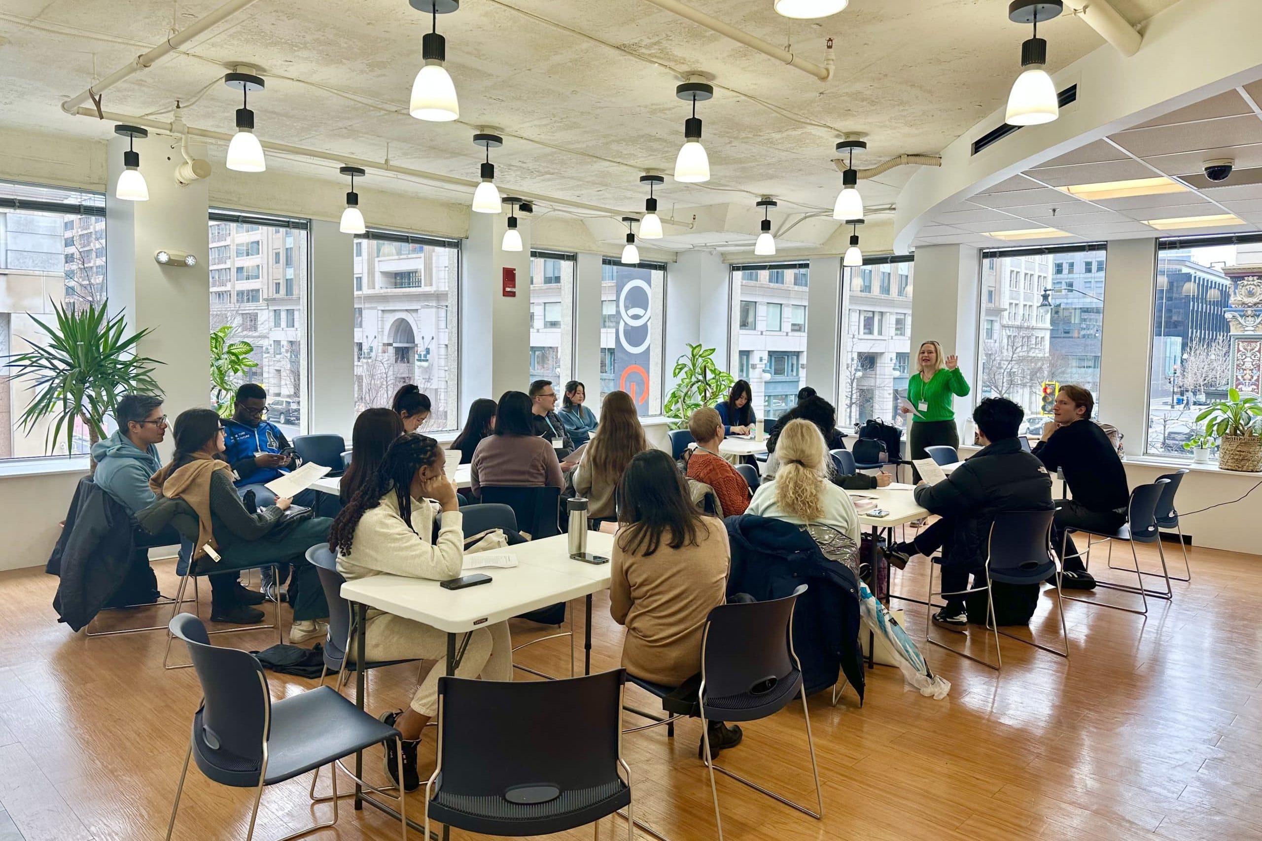 People sitting at tables in WEC's natural light-filled suite.